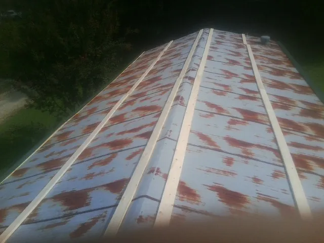 Rusted metal roof panels with new wood purlins before replacement — Storm Damage Roof Repair in Whittier by Roofing Brothers